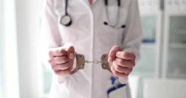 Doktor kardiyolog elleri kelepçeli. Estetik cerrah tutuklandı ve tıp suçları konsepti