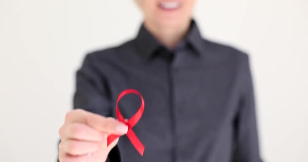 Hivの赤いリボンのシンボルを手に持っている女性が近づいています 世界エイズデーのコンセプト — ストック動画