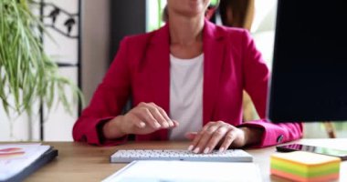 A woman sitting in the office affably waves her hand, a close-up. Meeting and parting at the workplace