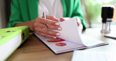 A woman sitting in the office watches documents, hands close-up. Workplace of the head, sales control