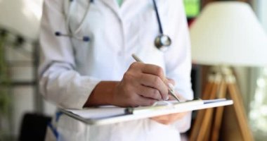 Doktor dosyanın üzerinde duruyor, yakın çekim, yavaş çekim. Hastanenin tıbbi kayıtları, sığ odak