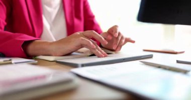 A woman in the office prints on a wireless keyboard, a close-up, slowmotion. The workplace of the entrepreneur