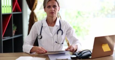 A question on paper is shown by a woman a doctor, a close-up, slowmotion. Medical competence, unknown disease