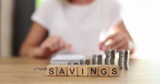 Savings Inscription Wooden Cubes Table Close Slowmotion Woman Folds Coins — Vídeo de Stock
