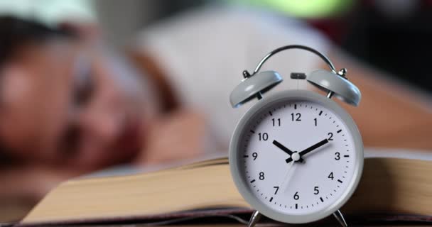 Uma Mulher Dorme Numa Mesa Com Livro Despertador Close Preparação — Vídeo de Stock