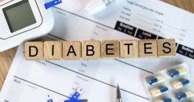 Diabetes inscription on wooden cubes on the doctor table, close-up. Tools and medicines for insulin resistance