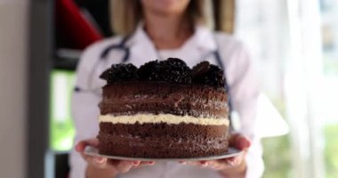 Chocolate cake in the hands of a doctor, close-up, slowmotion. Successful operation, holiday in the clinic