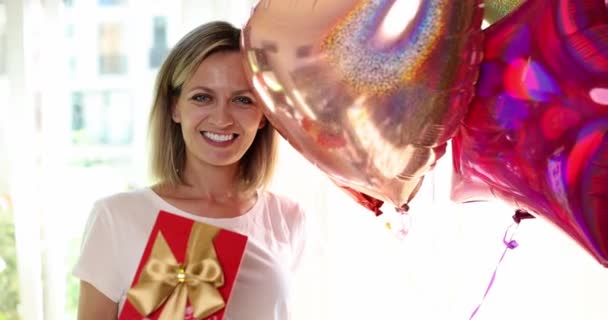 一个快乐的女人 手里拿着礼物和气球 一个特写 一个慢动作 恭喜你放假了 — 图库视频影像