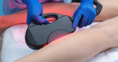 Master making laser epilation of skin of legs of woman client in beauty salon closeup 4k movie slow motion. Unwanted hair removal concept