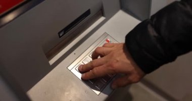ATM klavyesinde el yazısıyla pin kodu yazan adam 4K 'lık filmi yavaş çekimde kapatıyor. Modern bankacılık hizmetleri uzaktan konsept