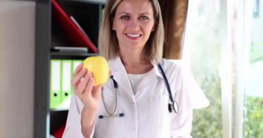 Smiling doctor nutritionist holding green apple in his hands 4k movie slow motion. Proper nutrition concept