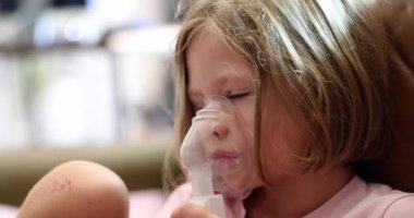 Little sick girl making inhalation with hormonal drug for laryngitis 4k movie slow motion. Pneumonia treatment concept