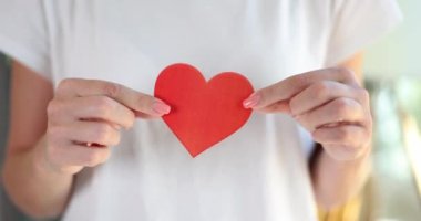 Female hands holding red paper heart closeup 4k movie slow motion. Valentine Day concept