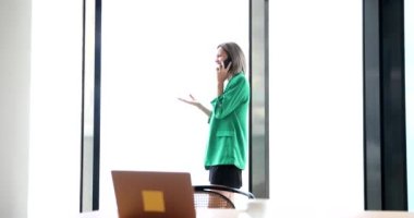 Businesswoman talking on mobile phone in office 4k movie slow motion. Break at work concept