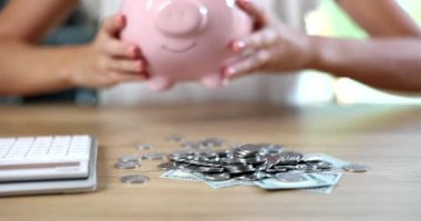 Female hands putting piggy bank on table in front of money closeup 4k movie slow motion. Family budget concept