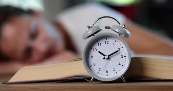 Gray Alarm Clock Standing Woman Sleeping Book Closeup Movie Slow — Stock Video