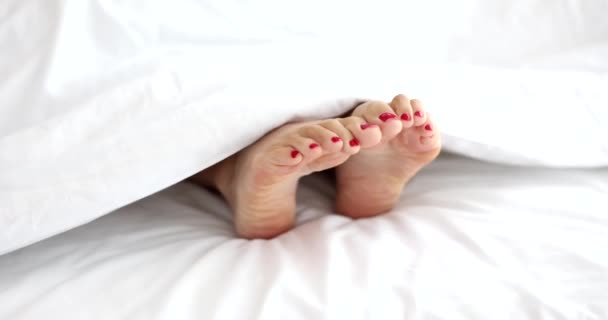 Weibliche Füße Mit Roter Pediküre Liegen Unter Einer Decke Film — Stockvideo