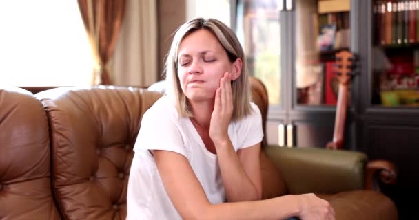 Woman Sitting Sofa Holding Her Hand Sore Cheek Movie Slow — Vídeo de stock
