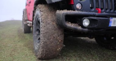 Dirty wheels of car standing on side of rural road closeup 4k movie slow motion. Off-road trips and travel concept