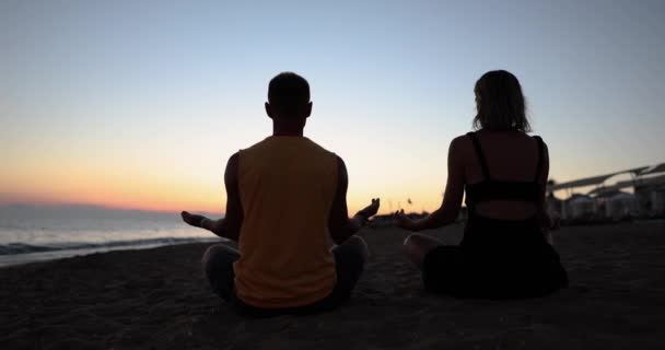 Young Couple Doing Yoga Seashore Sunset Back View Movie Slow — Video