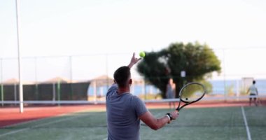 Tennis player plays tennis on court and serves ball. Tennis training and health