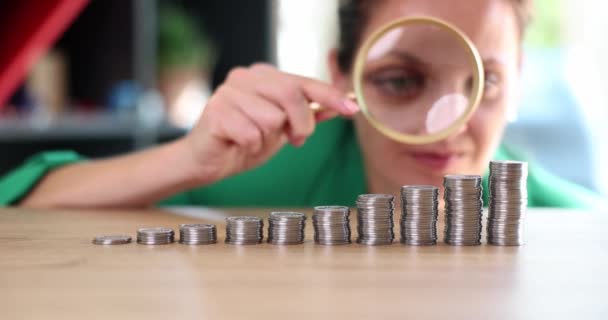 Businesswoman Looks Magnifying Glass Different Stacks Coins Table Symbol Financial — Vídeos de Stock