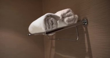 Two white towels in bathroom on shelf. Terry shower towels