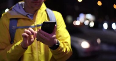 Sokak lambası taksisinde cep telefonu kullanan erkek eller. Seyahat güzergahı için blogger gezgini ve mobil uygulama