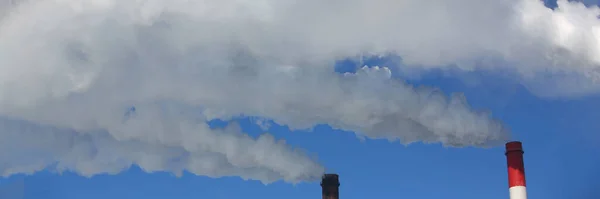 Chimney of factory plant against blue sky. Thermal condensing power plant concept