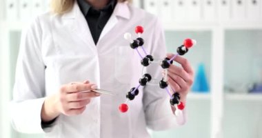 Kadın bilim adamı elinde moleküler yapının modelini gösteriyor. Eğitim kimyasal araştırma ve bilim