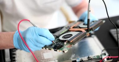 Technician with millimeters at workplace with and computer printed circuit board. Device for repairing and testing computers