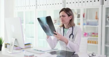 Traumatologist examines x-ray of leg of knee joint. Arthrosis of knee joint or gonarthrosis
