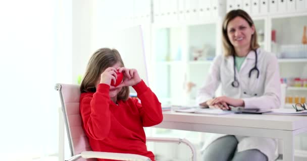 儿科医生和持有红心的小女孩 孩子们对医生的预约和儿童保险感到快乐 — 图库视频影像