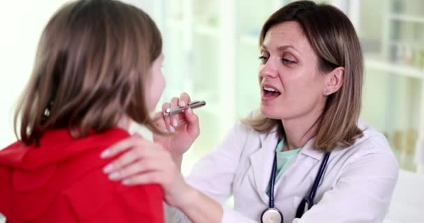 耳鼻喉科医生检查小女孩的喉咙和嘴 心绞痛是咽喉粘膜和淋巴组织中的传染性炎症过程 — 图库视频影像