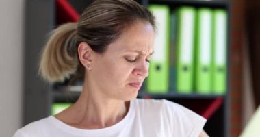 Portrait of young woman sniffing armpits and negative emotions. Hyperhidrosis in women