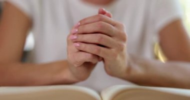 Female hands reading bible and praying in worship room in christian church. Faith hope and prayer concept