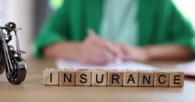 Motorcycle model and insurance agent filling out insurance on table. Motorcycle travel and medical insurance concept