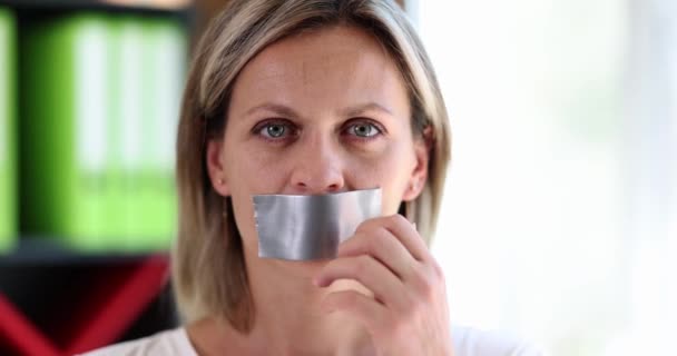 美しい女性は口からテープを剥ぎ取る 言論の検閲又は沈黙の自由の制限 家庭内暴力 — ストック動画