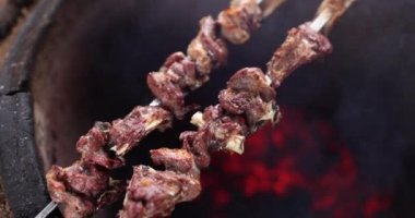 Barbecue cooking beef ribs on charcoal grill on skewers. Cooking barbecue meat ribs