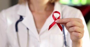 Dünya AIDS Günü ve Ulusal HIV ve AIDS farkındalığı ayı. Elinde kırmızı kurdeleyle doktor doktoru.