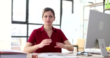 Woman shows prohibition gesture at workplace. Business rejection and negative gesture