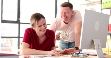 Happy business woman laughing at funny joke with friendly colleague in office. Cheerful happy team of colleagues happily talking at workplace