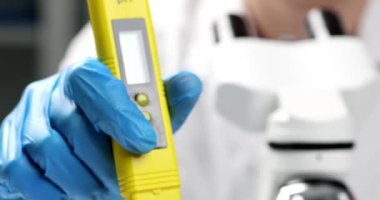Scientist conducts phytopathological testing of plants under microscope in laboratory by tester. Cultivation of organic products and testing of toxins