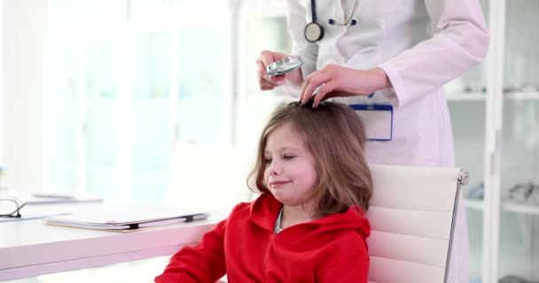 女医生通过放大镜检查儿童的头发 小儿脊柱侧弯可引起症状及诊断 — 图库视频影像