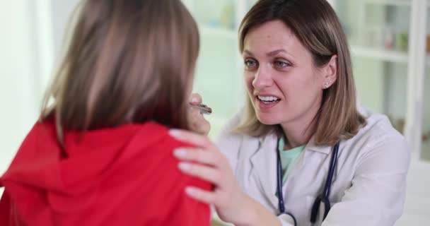 소녀는 벌리고 의사에게 인후염을 나타낸다 진단을 담당하는 Otolaryngologist 장치를 사용하여 — 비디오