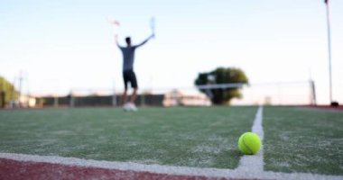 Profesyonel tenisçi tenis kortunda zaferin tadını çıkarır. Tenis oyunu ve spor zaferinin duyguları