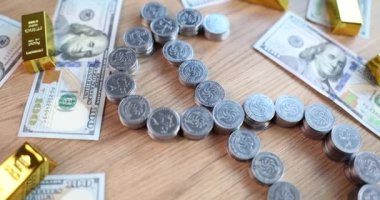 Dolar sembolü şeklinde sikkeler ve dolar banknotları olan altın külçeler. Para kazanmak ve finansal yatırım yapmak