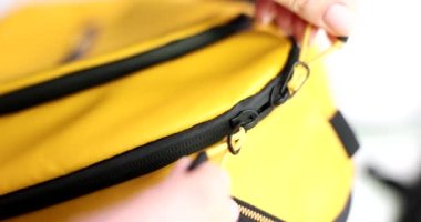 Woman hands unzip zipper in backpack or bag. Quality zippers for bags financial security