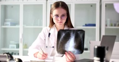 Doctor radiologist look to study human skeleton lungs x-ray film. Examination of chest and diagnosis of pathological changes