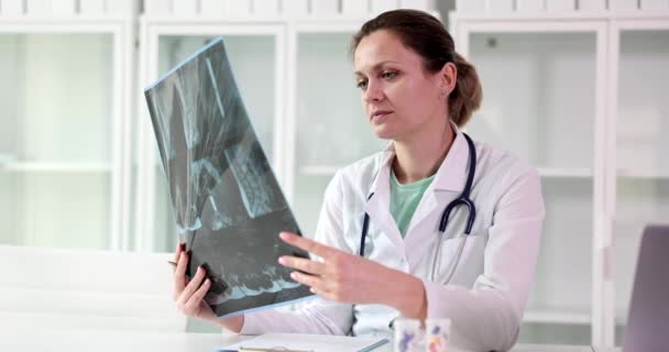 Γιατρός Εξετάζει Ακτινογραφία Σπονδυλικής Στήλης Στην Επιφάνεια Εργασίας Στην Κλινική — Αρχείο Βίντεο